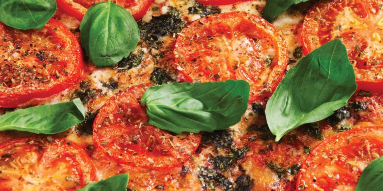 a close-up of basil leaves on pizza
